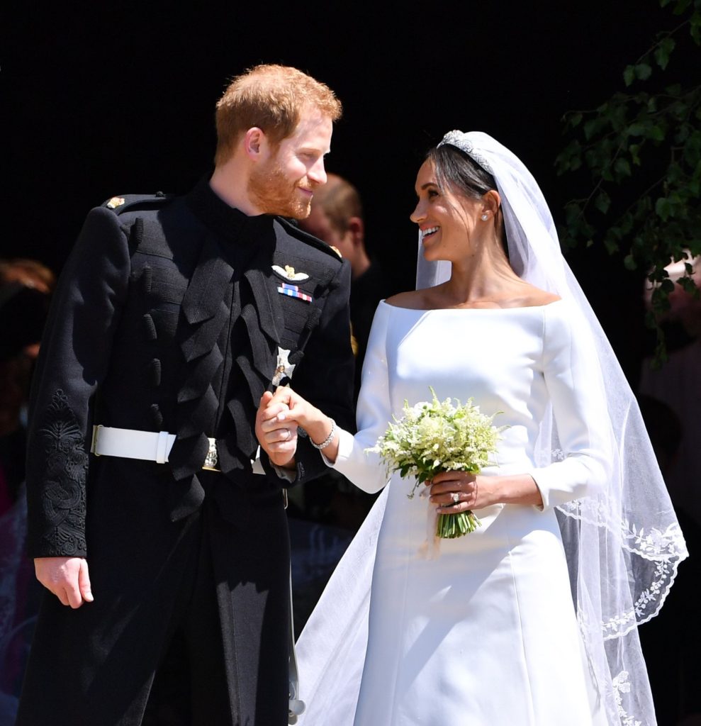Prince Harry and Meghan Markle holding hands on the steps of St. George's chapel after their wedding